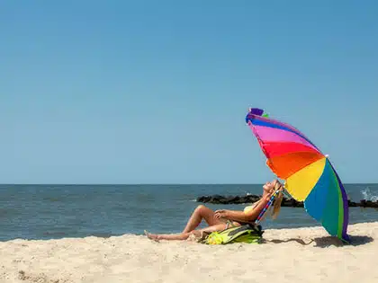woman on beach with umbrella
